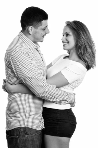 Joven pareja feliz sonriendo mientras se abrazan y se miran en el amor —  Fotos de Stock