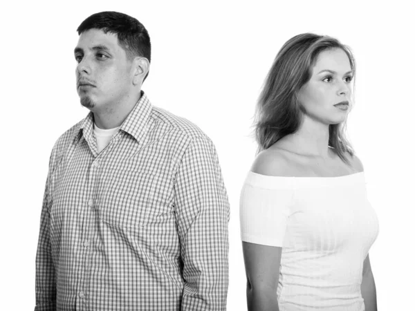 Studio shot of young couple with man looking left and woman looking right Royalty Free Stock Photos