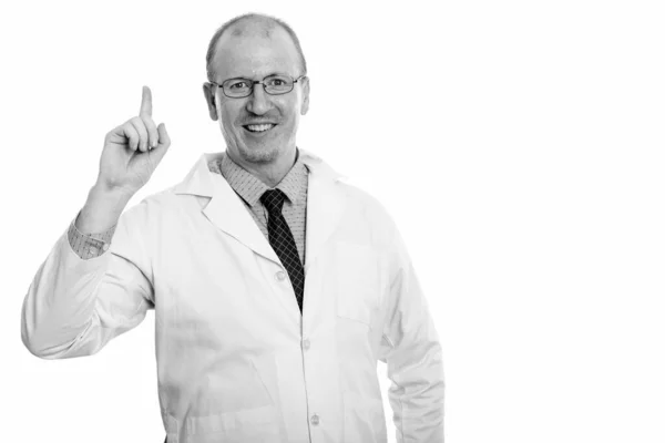 Estúdio tiro de homem feliz médico sorrindo ao apontar o dedo para cima — Fotografia de Stock