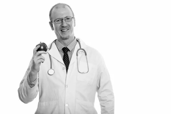 Estúdio tiro de homem feliz médico sorrindo enquanto segurando maçã — Fotografia de Stock