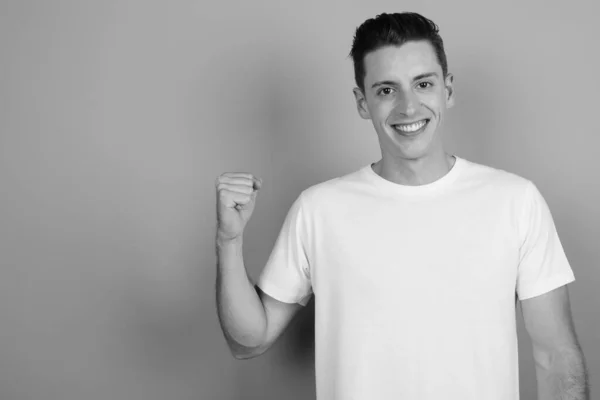 Joven hombre guapo sobre fondo gris — Foto de Stock