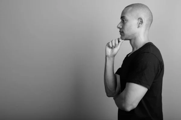 Snygg skallig man bär svart skjorta mot grå bakgrund — Stockfoto