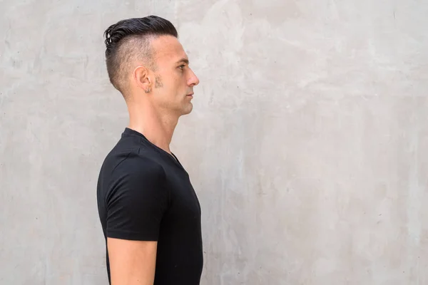 Profile of handsome young Italian man with undercut wearing black t-shirt