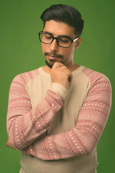 Young bearded Iranian man against green background — Stock Photo, Image