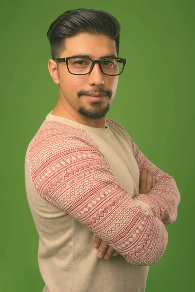 Mladý vousatý íránský muž na zeleném pozadí — Stock fotografie
