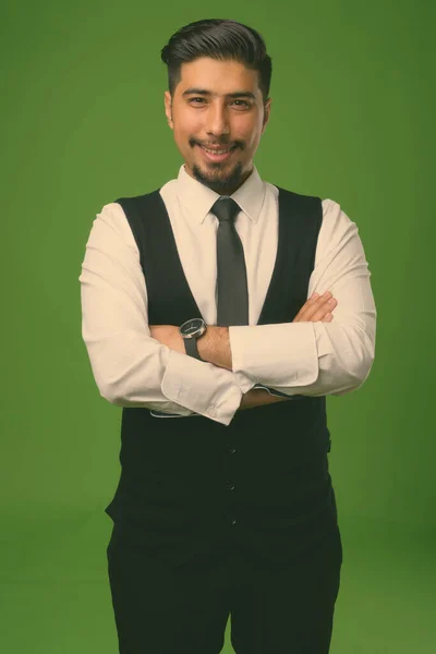 Junger bärtiger iranischer Geschäftsmann mit grünem Hintergrund — Stockfoto