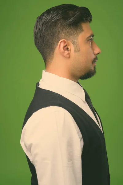 Jovem barbudo iraniano empresário contra fundo verde — Fotografia de Stock