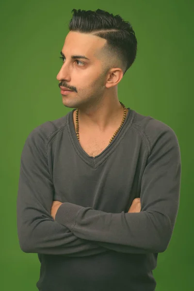 Joven hombre iraní guapo con bigote sobre fondo verde — Foto de Stock