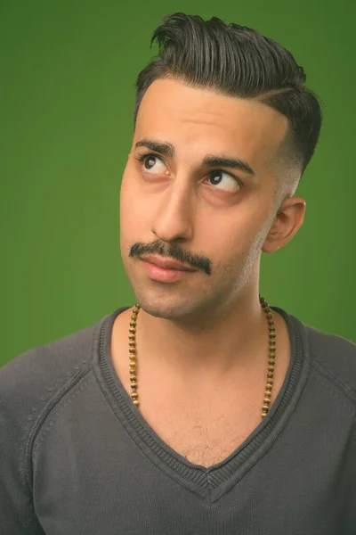 Giovane uomo iraniano bello con i baffi sullo sfondo verde — Foto Stock