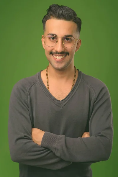 Jovem iraniano bonito com bigode contra fundo verde — Fotografia de Stock