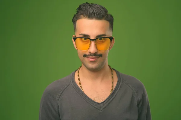 Joven hombre iraní guapo con bigote sobre fondo verde — Foto de Stock