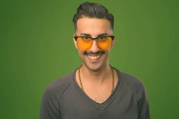 Ung stilig iransk man med mustasch mot grön bakgrund — Stockfoto