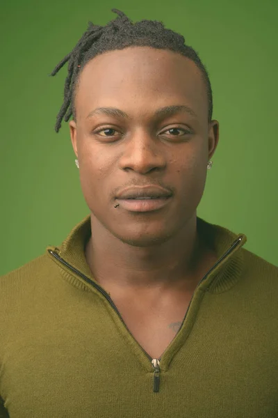 Junger schöner afrikanischer Mann aus Kenia vor grünem Hintergrund — Stockfoto
