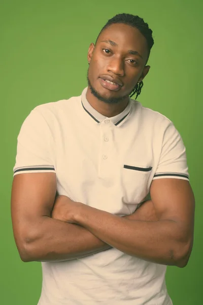 Young handsome African man from Kenya against green background — Stock Photo, Image