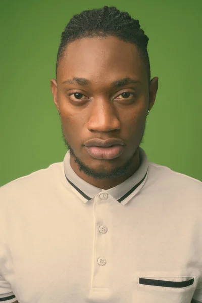 Young handsome African man from Kenya against green background — Stock Photo, Image