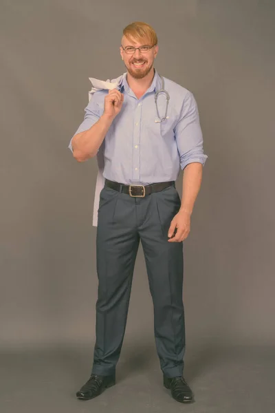 Bearded man läkare med blont hår mot grå bakgrund — Stockfoto