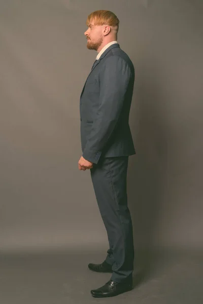 Бородатий бізнесмен з світлим волоссям на сірому фоні — стокове фото