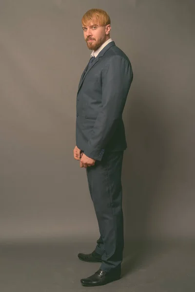 Uomo d'affari barbuto con i capelli biondi sullo sfondo grigio — Foto Stock