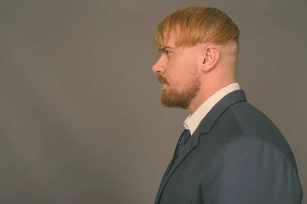 Empresario barbudo con cabello rubio sobre fondo gris —  Fotos de Stock