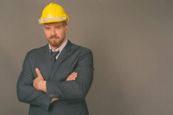 Empresario barbudo con hardhat sobre fondo gris — Foto de Stock