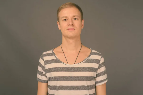 Retrato de homem bonito jovem contra fundo cinza — Fotografia de Stock