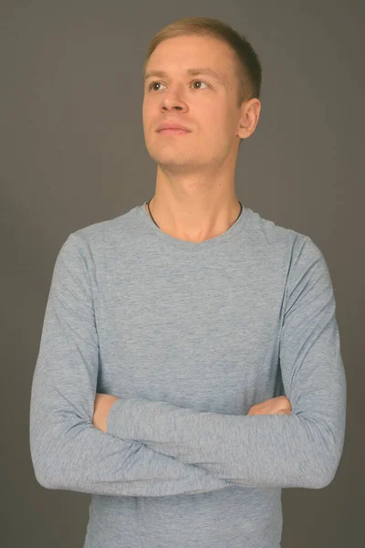 Retrato de homem bonito jovem contra fundo cinza — Fotografia de Stock