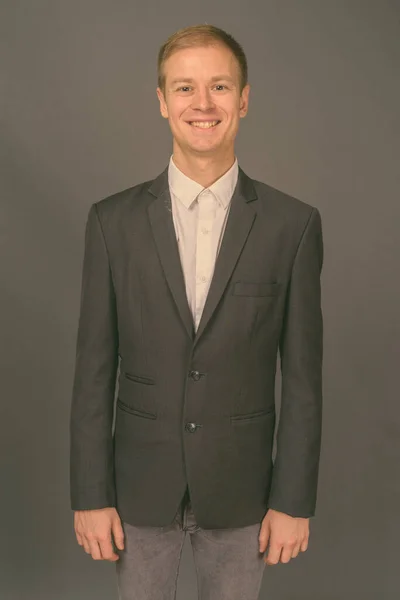 Portret młodego przystojnego biznesmena na szarym tle — Zdjęcie stockowe
