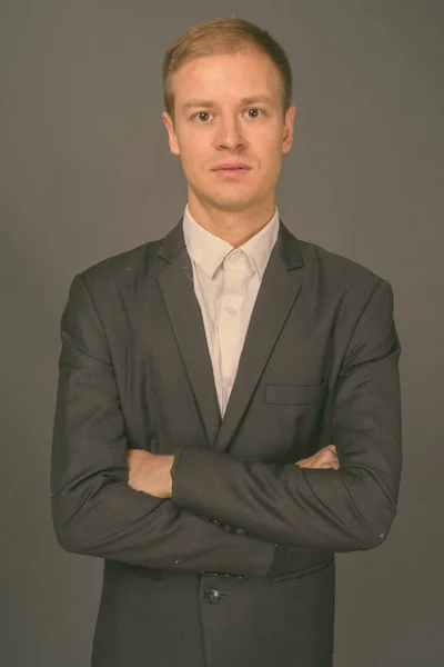 Retrato de joven hombre de negocios guapo sobre fondo gris — Foto de Stock