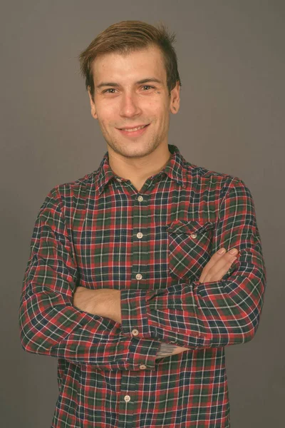 Retrato de un joven guapo sobre fondo gris — Foto de Stock