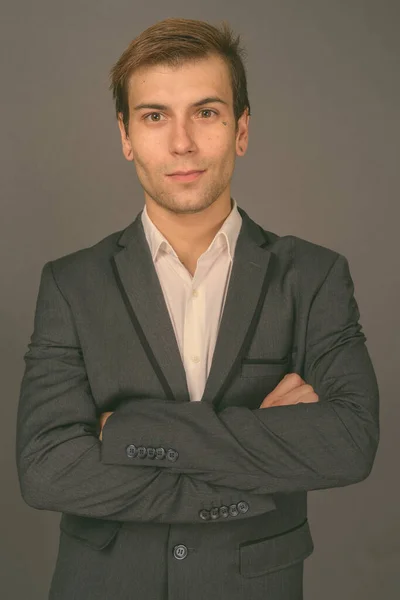 Retrato de joven hombre de negocios guapo sobre fondo gris — Foto de Stock