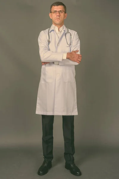 Handsome man doctor with short hair against gray background — Stock Photo, Image