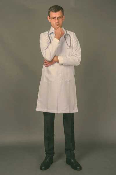 Handsome man doctor with short hair against gray background — Stock Photo, Image