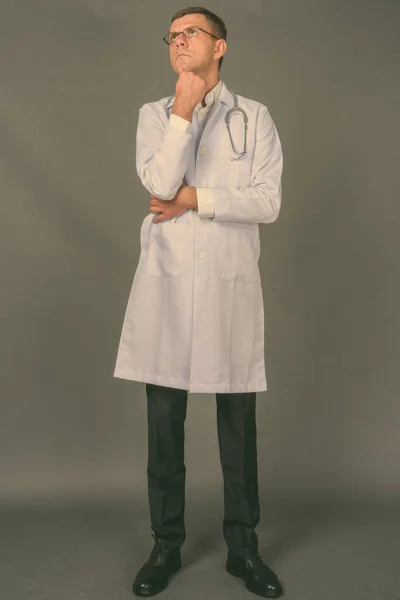Przystojny mężczyzna lekarz z krótkimi włosami na szarym tle — Zdjęcie stockowe