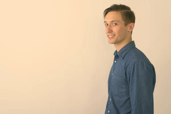 Estudio toma de feliz joven guapo hombre sonriendo sobre fondo blanco — Foto de Stock