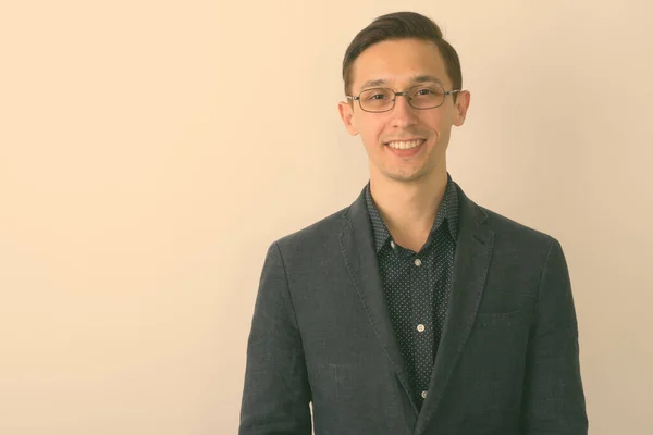 Primo piano di giovane uomo d'affari felice sorridente mentre indossa occhiali su sfondo bianco — Foto Stock