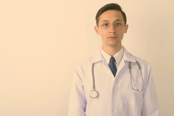 Close up of young handsome man doctor wearing eyeglasses against white background — Stock Photo, Image