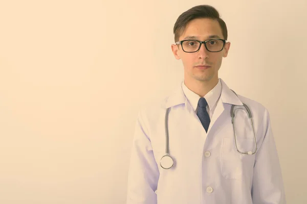 Primer plano del joven y guapo empollón doctor usando anteojos sobre fondo blanco — Foto de Stock