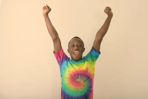 Estudio de un joven negro africano feliz con ambos brazos levantados sobre fondo blanco — Foto de Stock