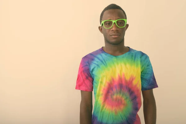 Studio záběr mladé černošky Afričan muž na sobě barevné košile a zelené brýle proti bílému pozadí — Stock fotografie