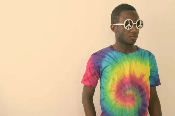 Studio colpo di giovane nero africano uomo hippie indossare occhiali da sole con segno di pace su sfondo bianco — Foto Stock