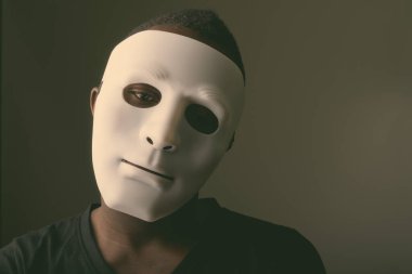 Siyah Afrikalı bir adamın karanlık odada maske taktığı bir fotoğraf.