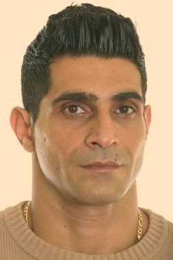 Genç kaslı İranlı adamın yüzü kameraya bakıyor.