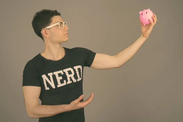 Jovem nerd bonito homem com óculos contra fundo cinza — Fotografia de Stock