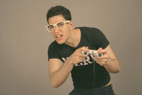 Jovem nerd bonito homem com óculos contra fundo cinza — Fotografia de Stock