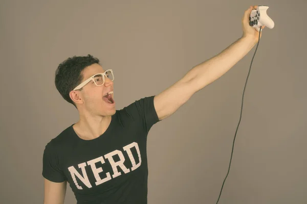 Jovem nerd bonito homem com óculos contra fundo cinza — Fotografia de Stock