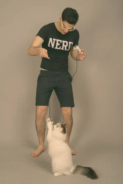 Joven hombre nerd guapo con anteojos sobre fondo gris —  Fotos de Stock