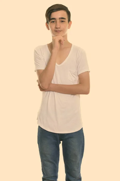 Studio bild av ung vacker persisk tonåring pojke stående medan tänker — Stockfoto