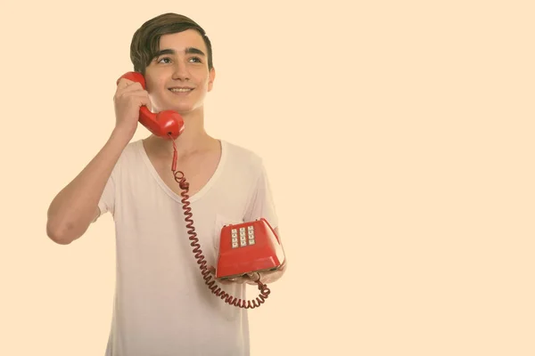 Στιγμιότυπο στούντιο του νεαρού ευτυχισμένου Πέρση έφηβου αγοριού χαμογελά και σκέφτεται ενώ μιλάμε στο παλιό τηλέφωνο — Φωτογραφία Αρχείου