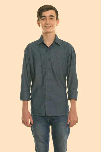 Studio shot of young happy Persian teenage boy smiling and standing — Stock Photo, Image