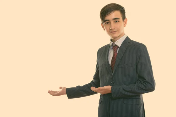 Studioaufnahme eines jungen, gut aussehenden persischen Geschäftsmannes, der etwas an der Wand zeigt — Stockfoto